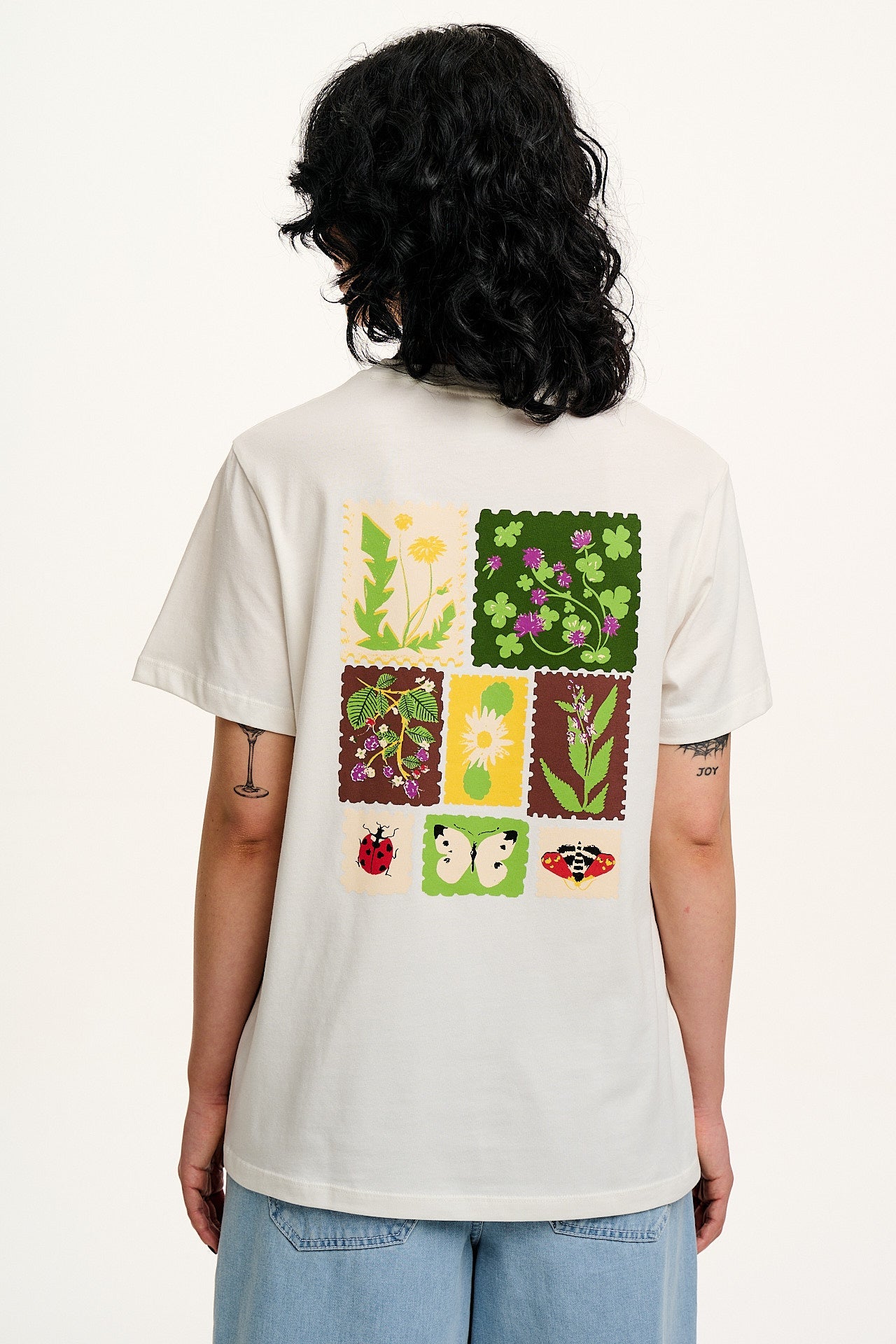 Person wearing a white t-shirt with nature-themed graphic on the back